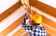 Electrician installing fixture in residential space
