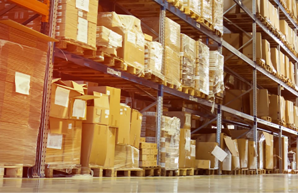 Warehouse shelves filled with boxes and packaged materials for on-site storage solutions.