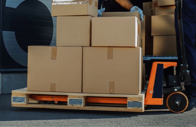 Pallet jack moving stacked boxes for flexible delivery service.